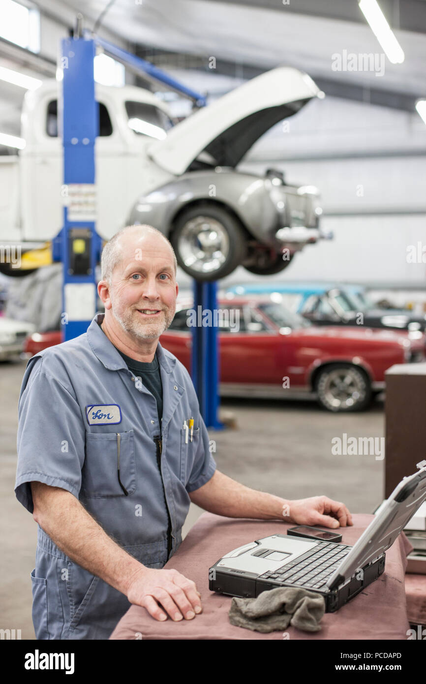 Portrait of a senior caucasian male owner of an antique car repair shop