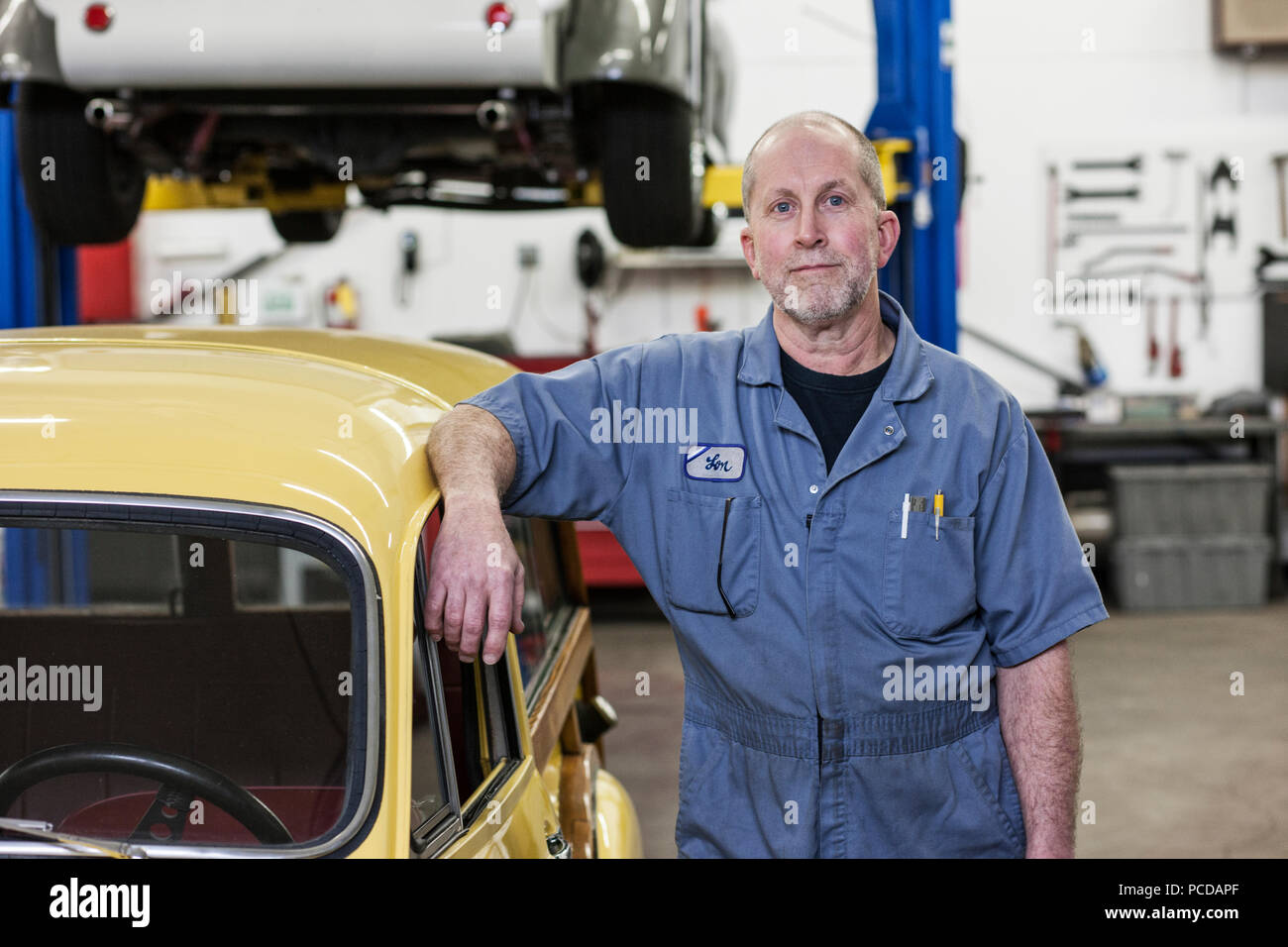 Portrait of a senior caucasian male owner of an antique car repair shop