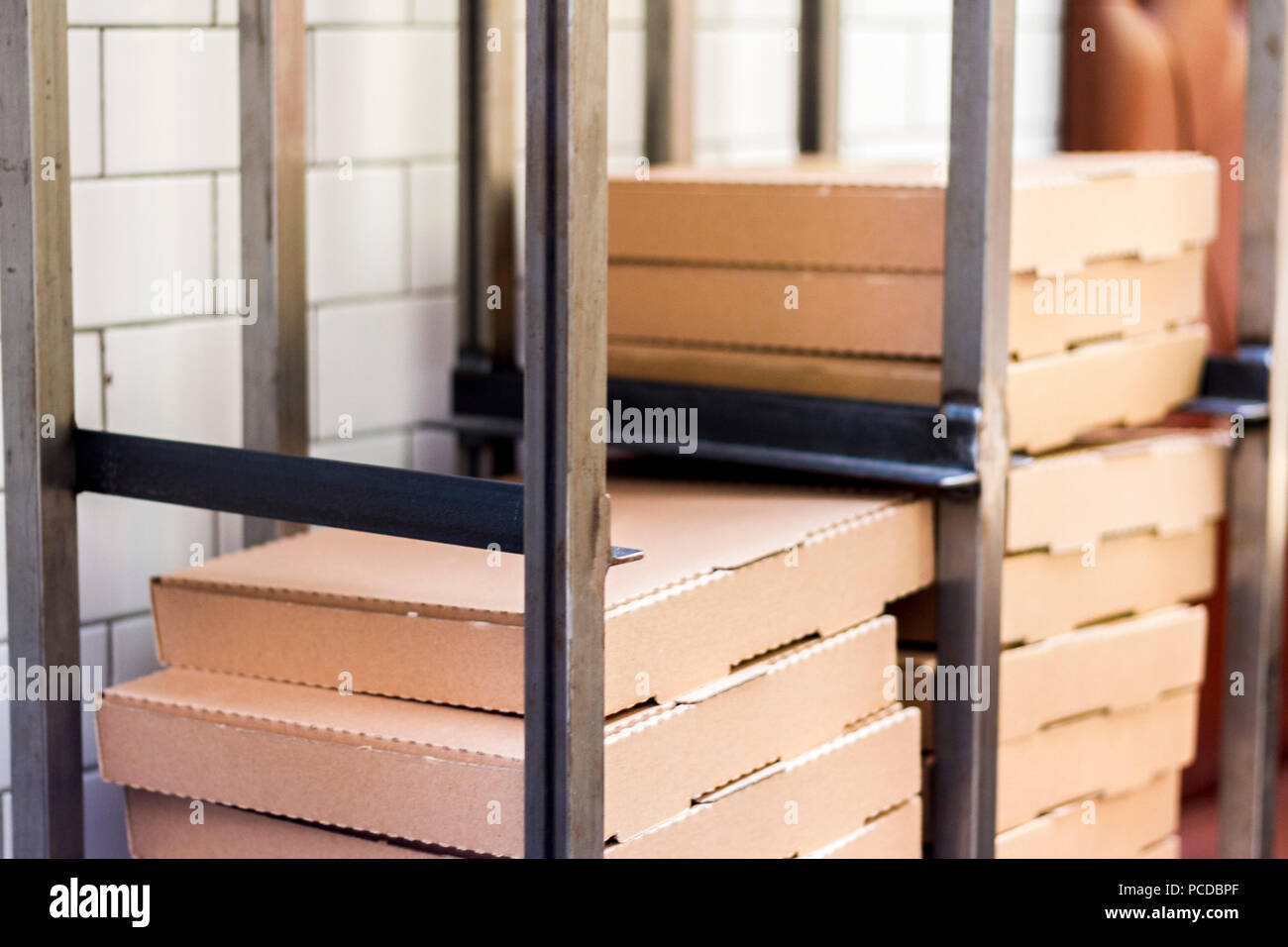 Pile, stack of empty new plain, brown cardboard, pizza boxes in a