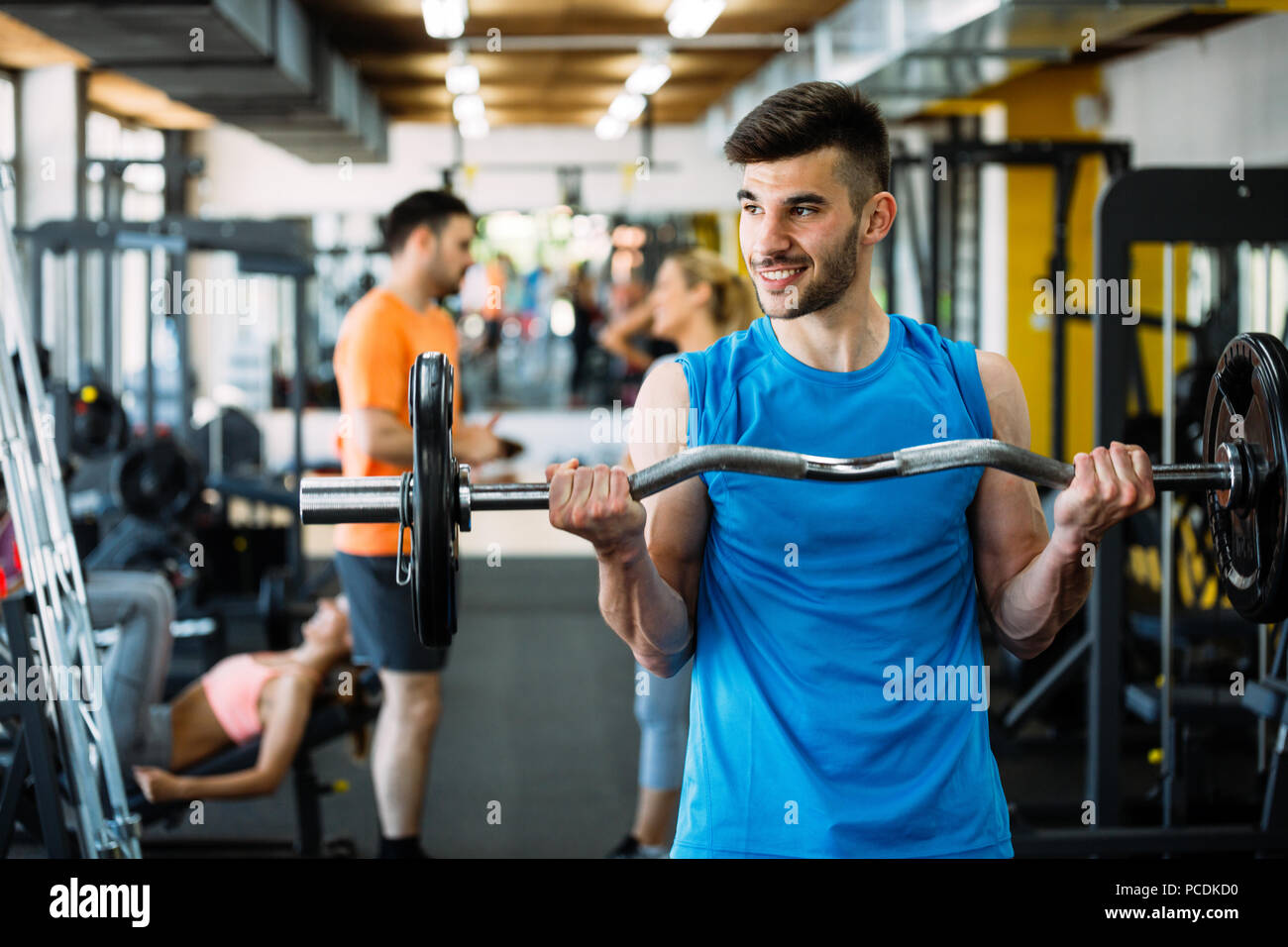 Athlete muscular bodybuilder in gym training biceps Stock Photo