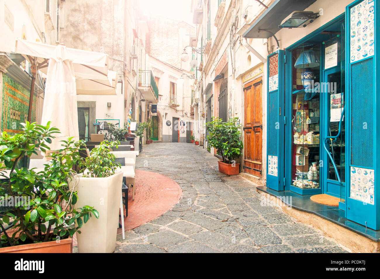 VIETRI-SUL-MARE, ITALY - 3 SEPTEMBER, 2017: view of empty narrow street full of cafes and souvenir shops in early morning with sun shining through the Stock Photo