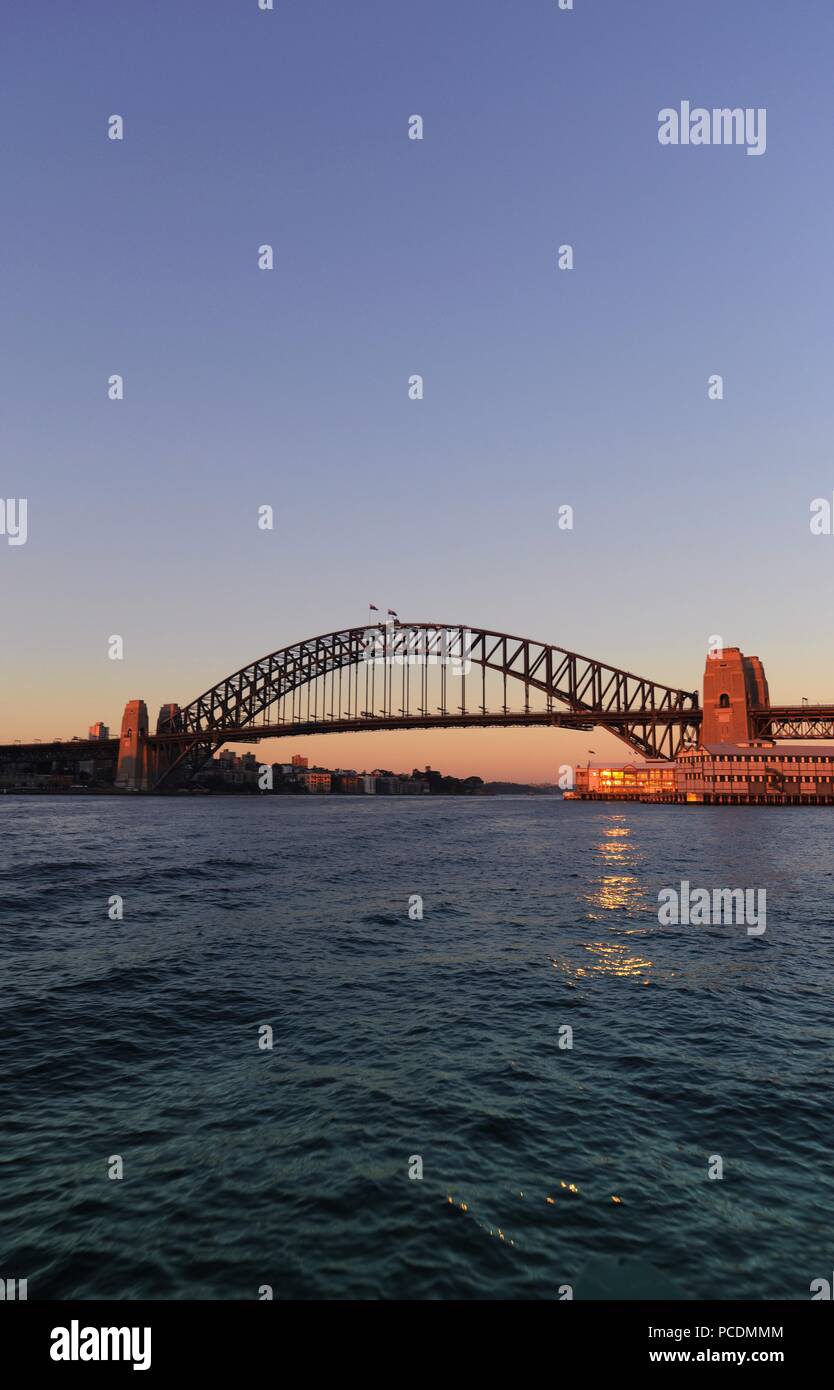Sydney Harbour Bridge at sunset, with sunlight reflecting on to the sea, Sydney, NSW, Australia Stock Photo