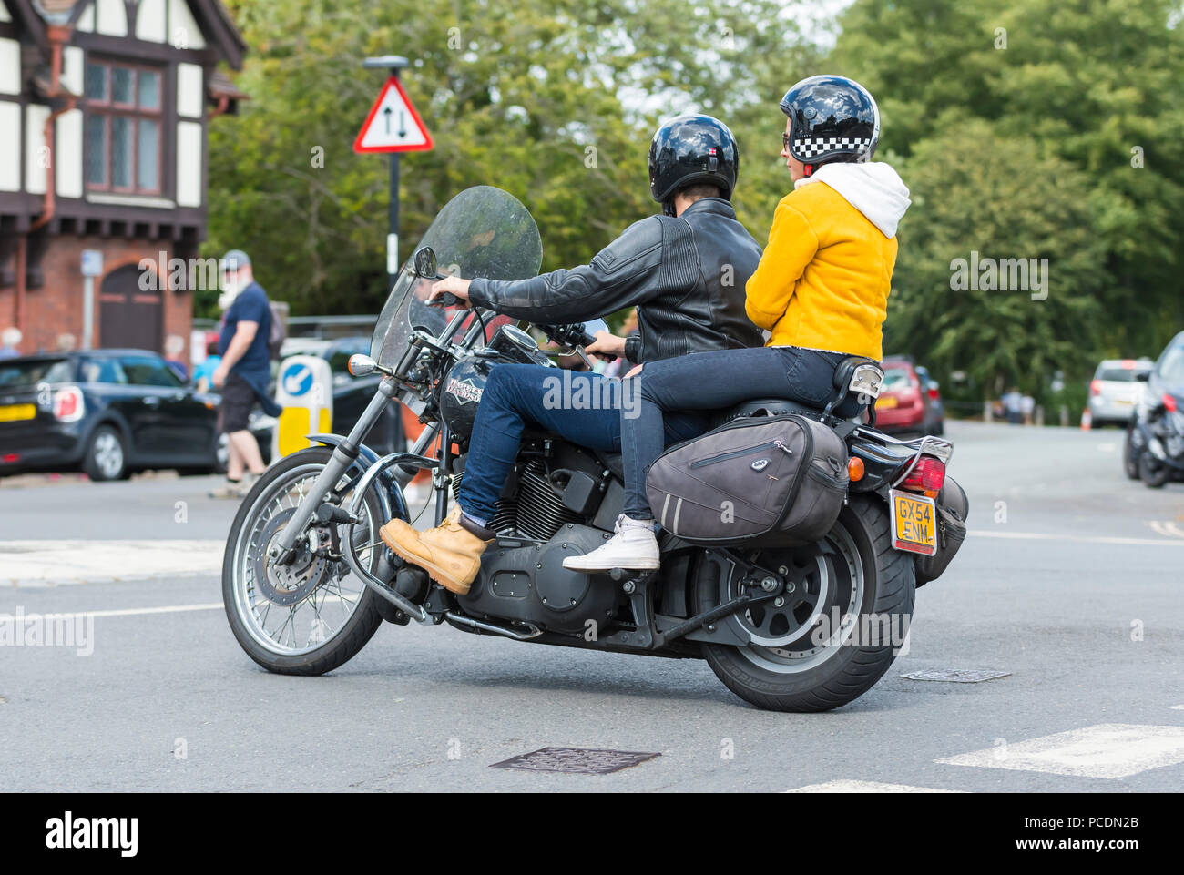 Person with pillion passenger riding a Harley-Davidson Bike FXSTBI Softail Night Train motorbike from 2004 in West Sussex, England, UK. Stock Photo