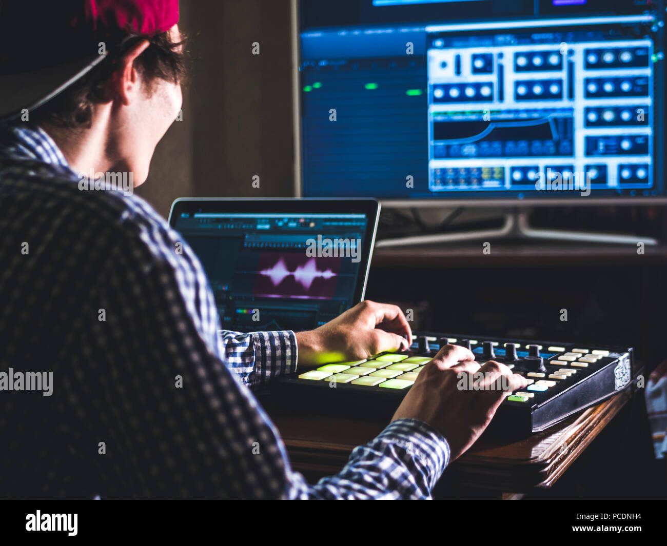 young male sound engineer working in professional music studio with ...