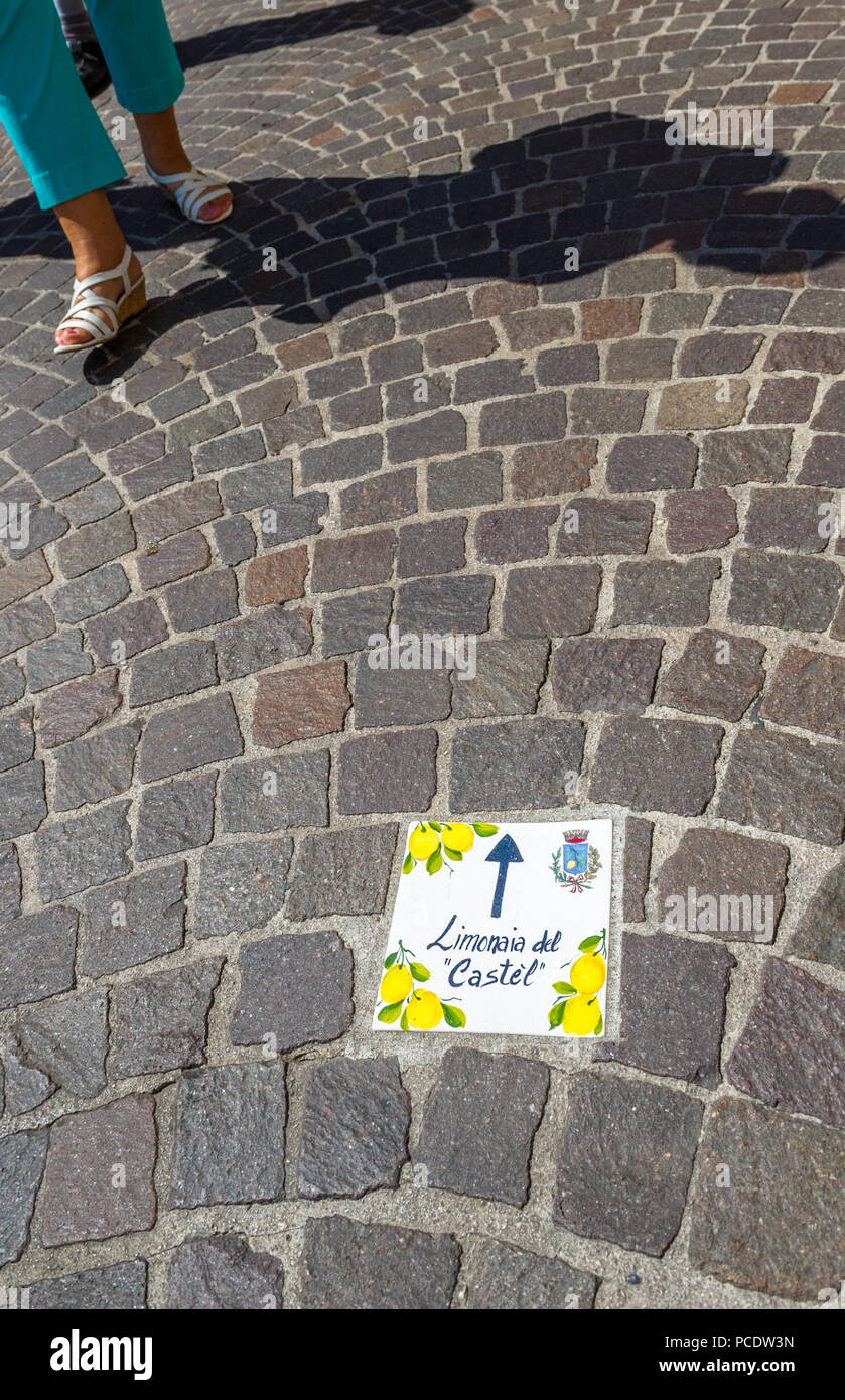 Decorative ceramic floor tiles showing the direction to the lemon castle in Limone, Italy. Stock Photo