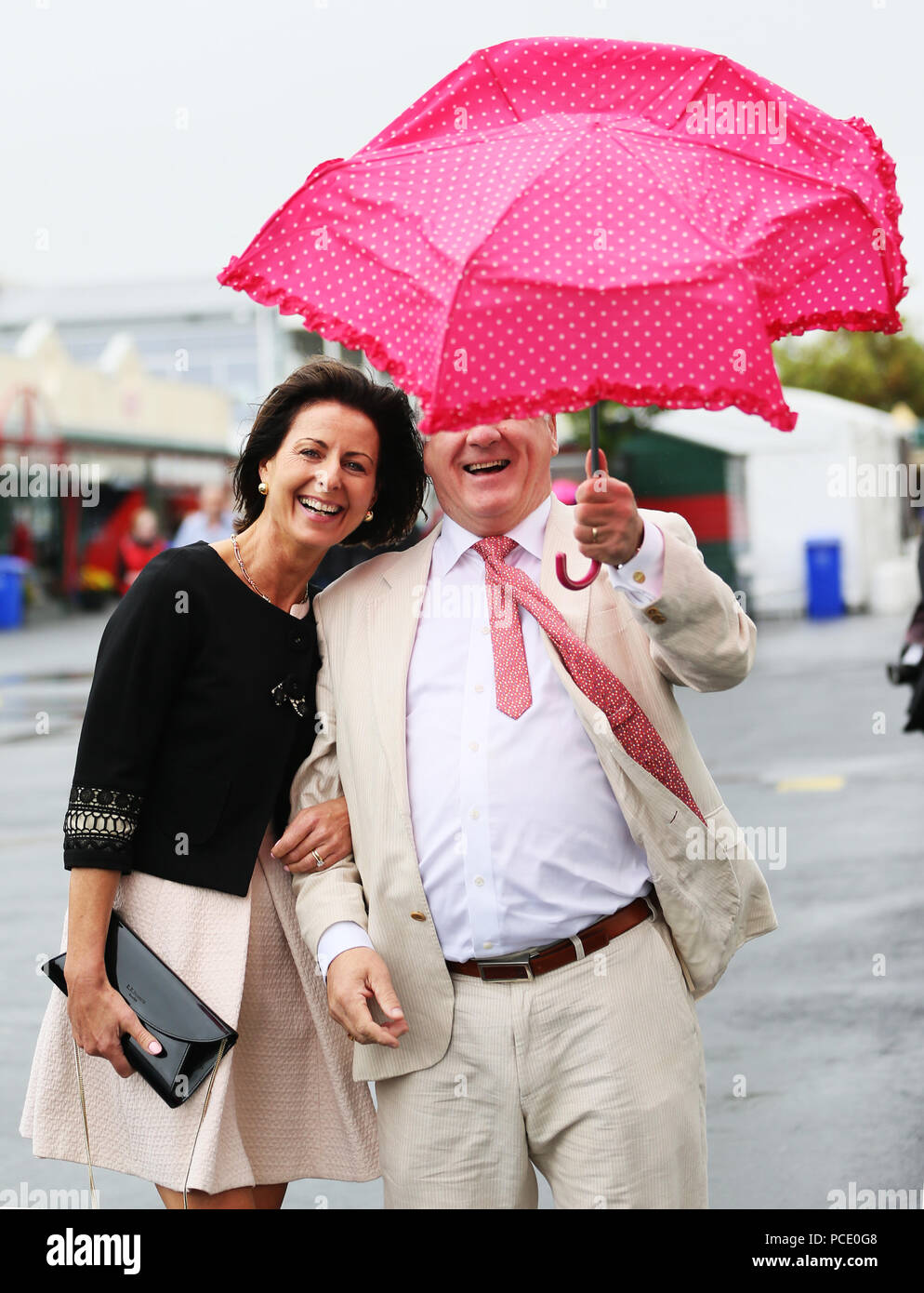 Louise Colleally and her husband Albert, from Athenry, struggle with their umbrella ahead of the start of racing on day three of the Galway Summer Festival at Galway Racecourse. Stock Photo