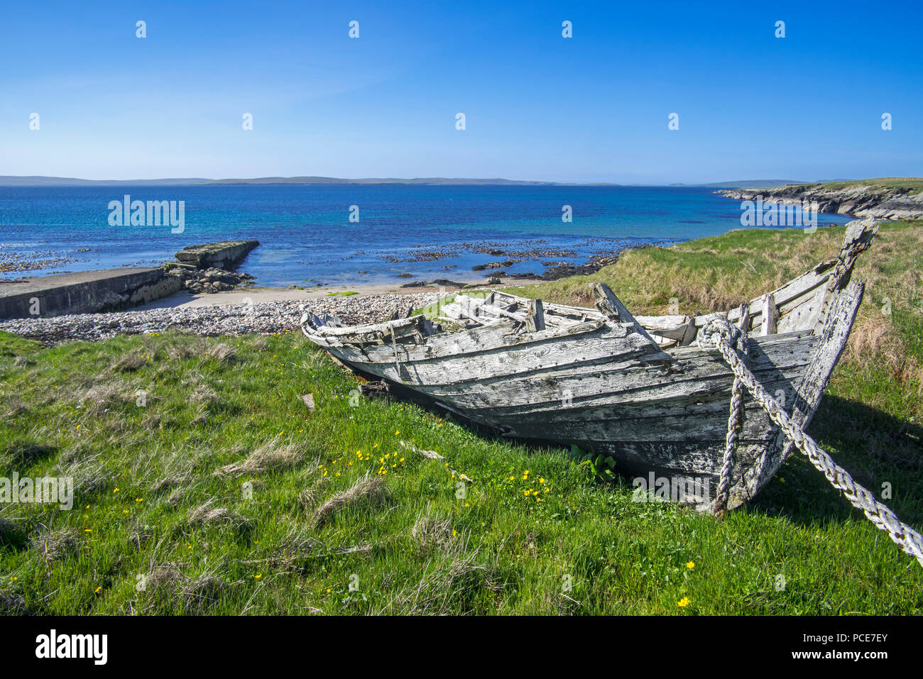 Old pier and remains of the Fetlar flit boat roped to the winding gear at Brough, Fetlar, Shetland Islands, Scotland, UK Stock Photo