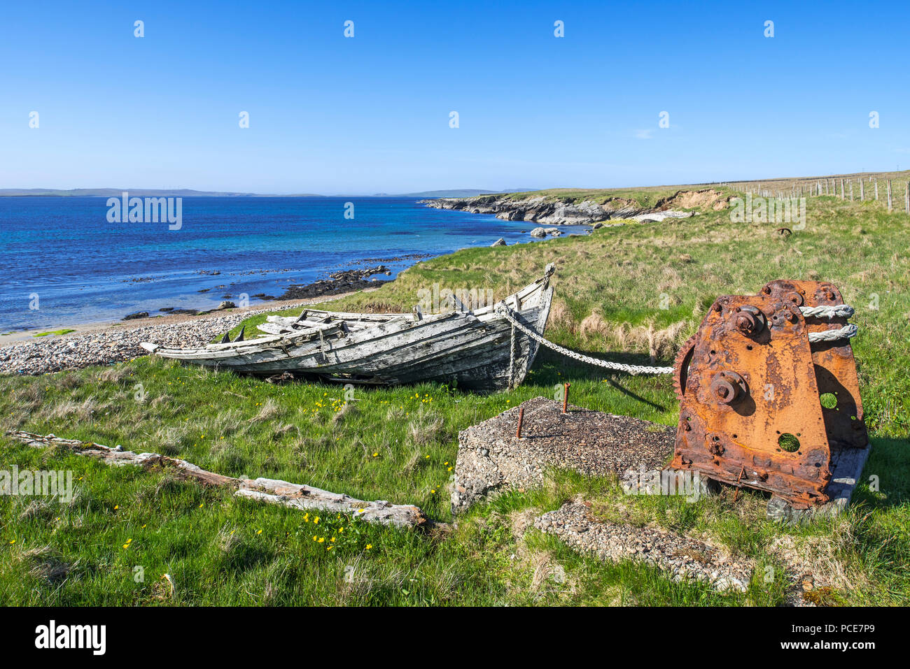 Remains of the old Fetlar flit boat roped to the winding gear / rusty winch at Brough, Fetlar, Shetland Islands, Scotland, UK Stock Photo