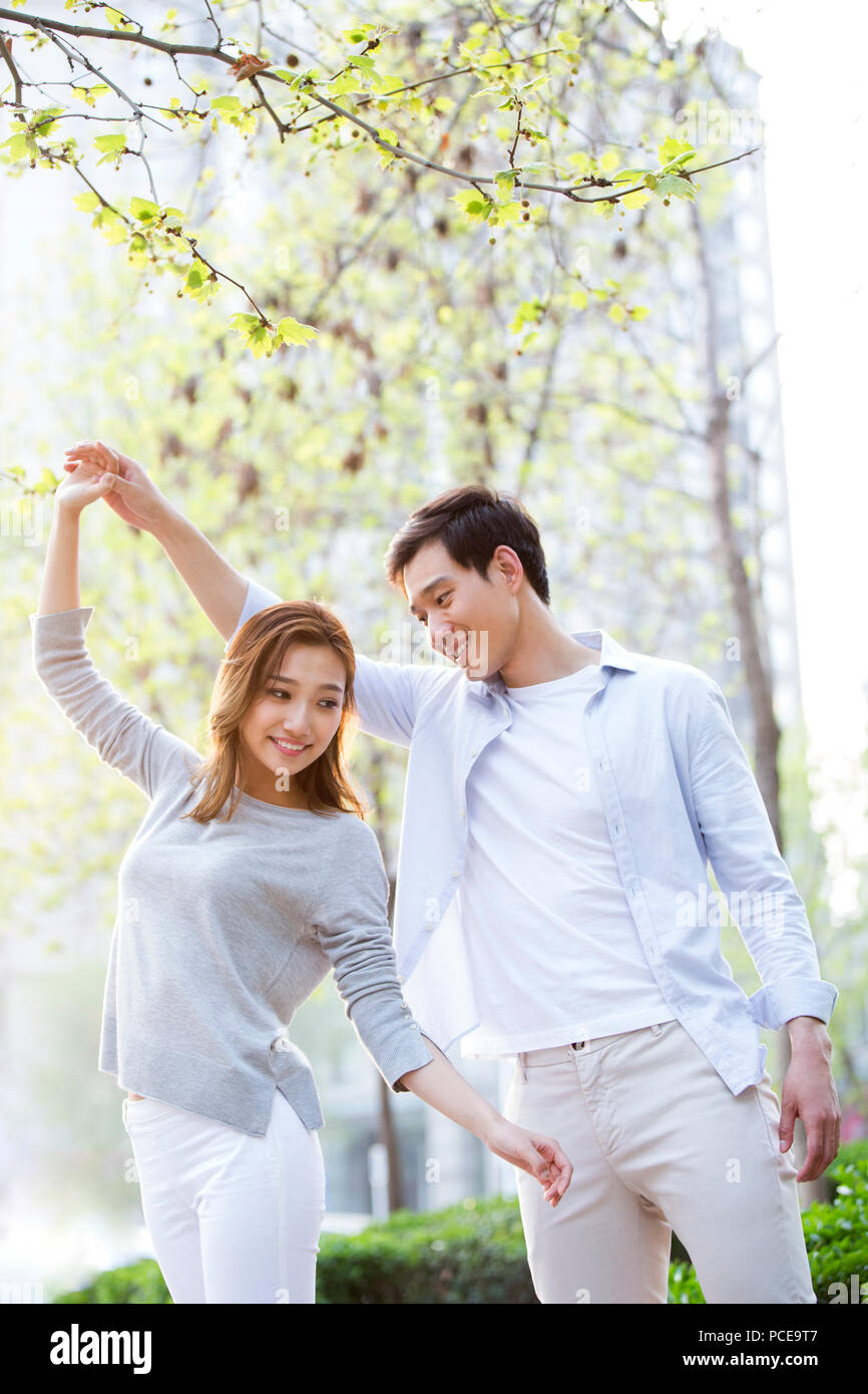 Happy young Chinese couple dancing outdoors Stock Photo