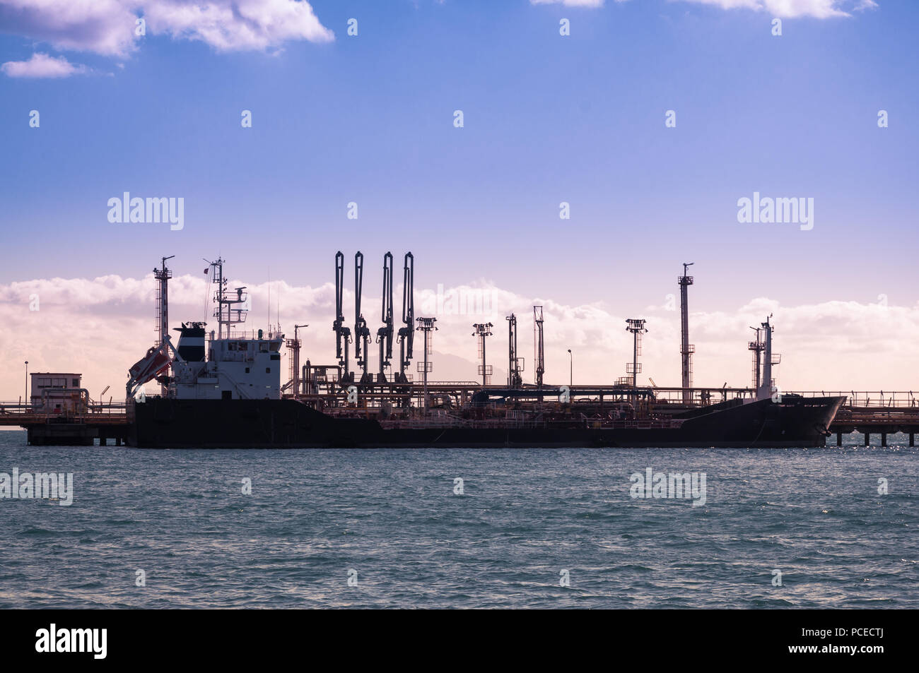 Petrol ship supplying petrol to a refinery Stock Photo