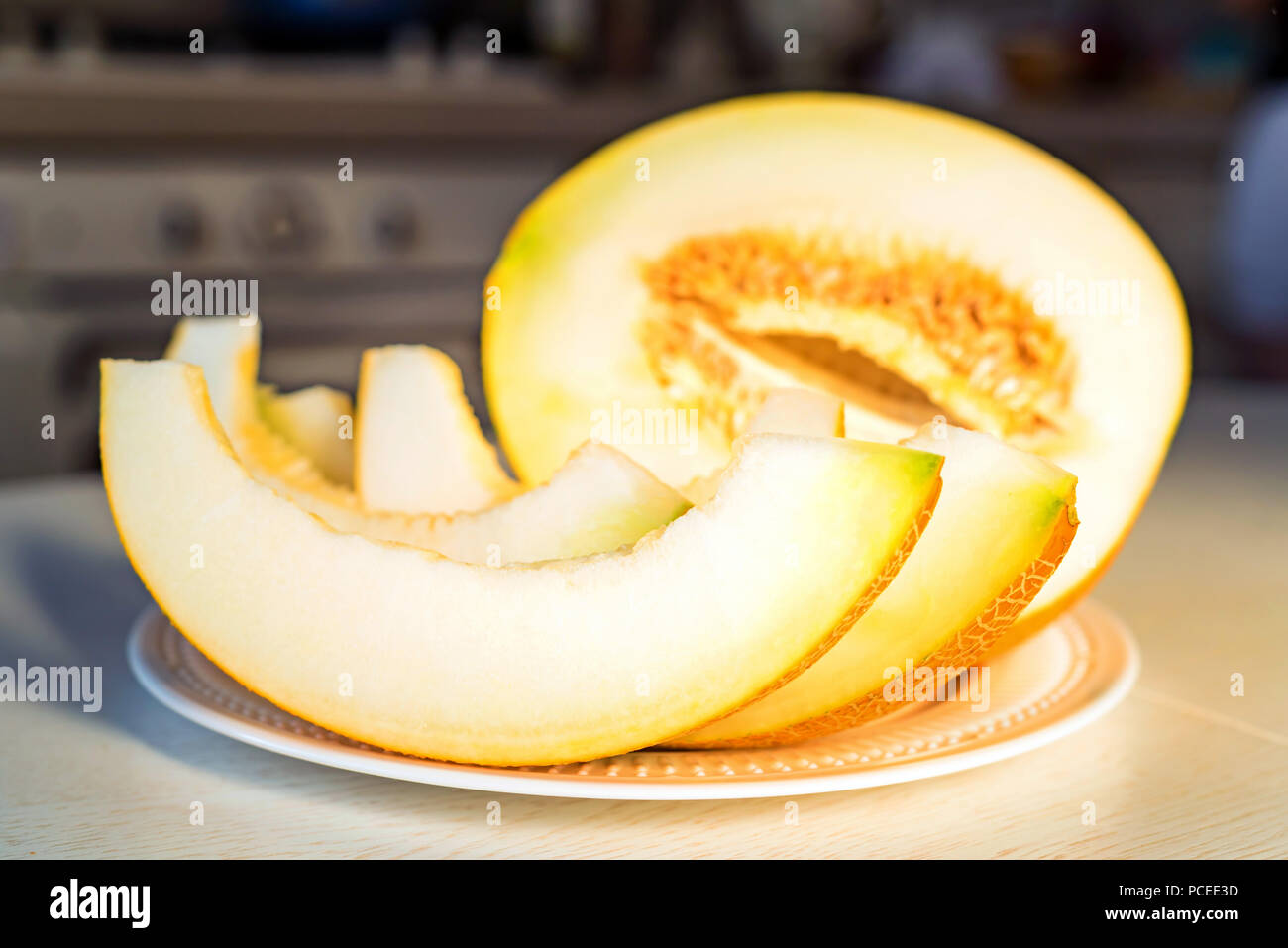 Half melon and melon slices on white plate close Stock Photo