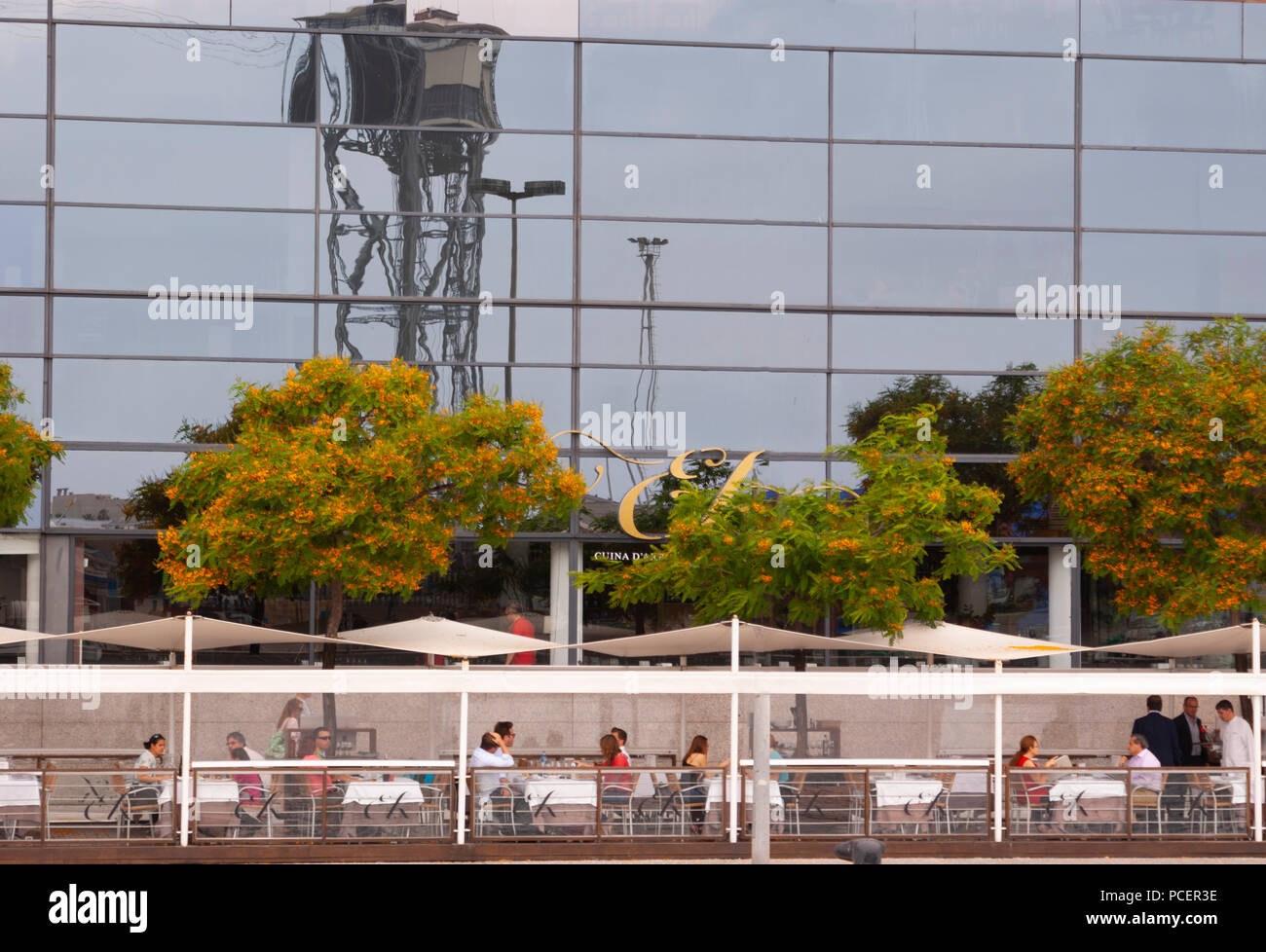 Barcelona Spain Harbour Port Vell People Eating Outside with Reflections Showing the Cable Car Station Stock Photo