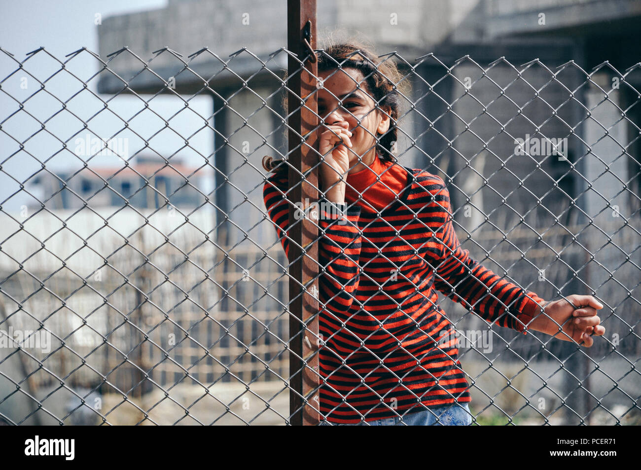 Nour stand behind the fence in the camp of southern area of Tartus Syria Stock Photo
