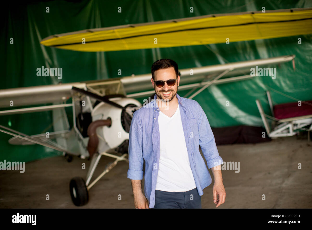 Handsome young pilot checking ultralight airplane before flight Stock Photo