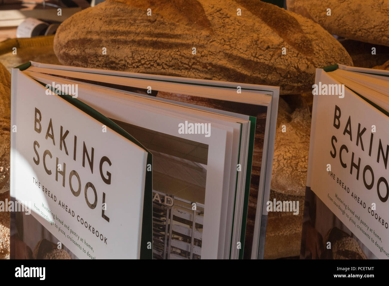 cookery and baking books and bread on sale at an artisan bakers stall on borough market in london. Stock Photo
