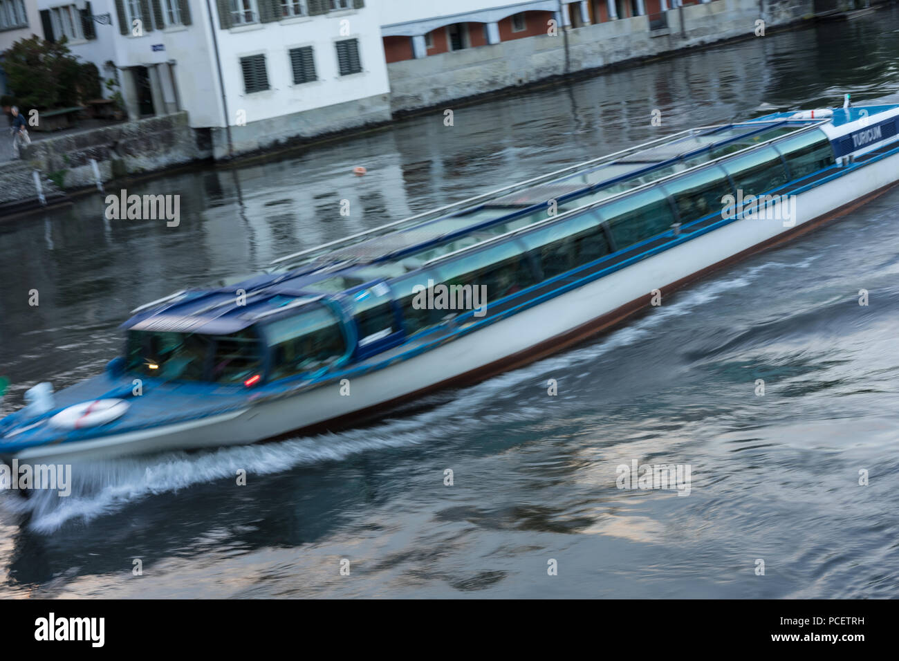 Zurich City Panorama with limmat river and small cruise ship at evening