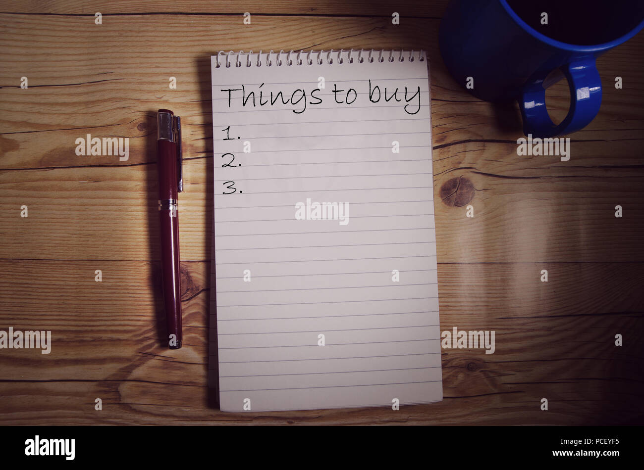 Notebook on the table with words written on one page with pen and coffee mug on both sides Stock Photo