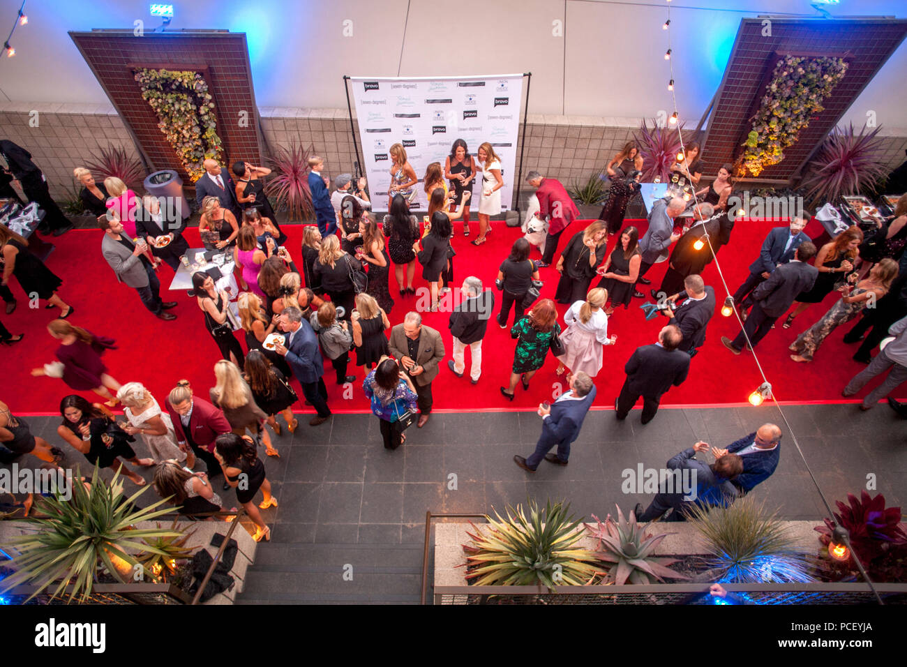 Cast members mix with invited guests at a party publicizing the reality TV show 'Real Estate Wars' in Laguna Beach, CA. In center is a background for people posing for photographers.  (Photo by Spencer Grant) Stock Photo