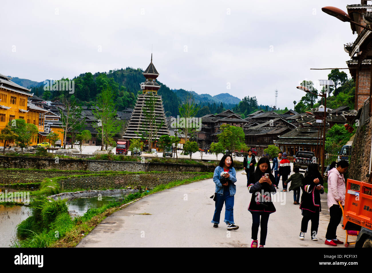 Typical Dong Village,Wooden Houses,Huanggang Dong Village,Dong Costumed Girls,Singing to Students,,Dwellings,Guizjou,PRC,People's Republic of China Stock Photo