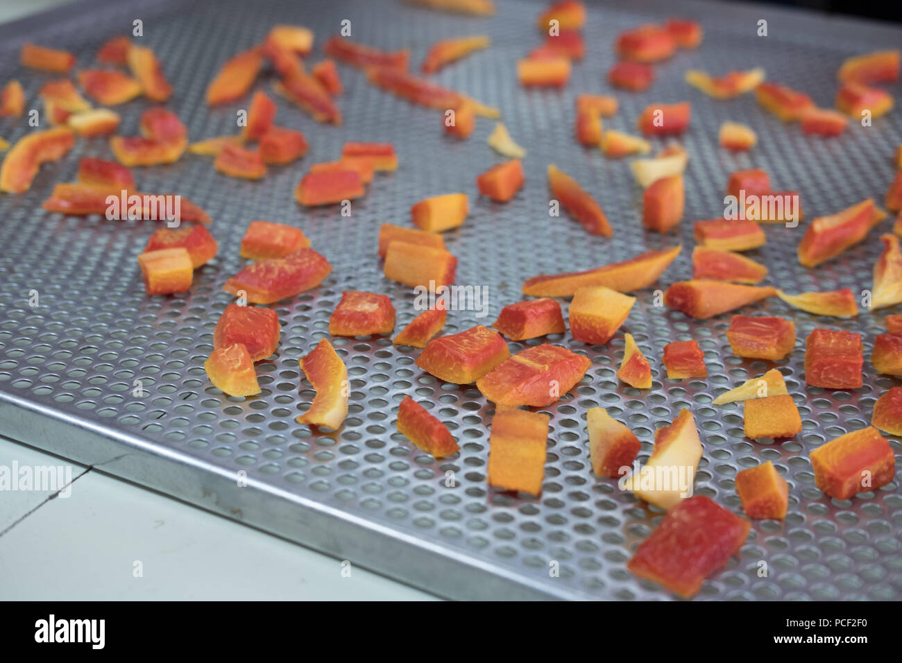 tropical fruit drying in hot air oven. dried carrot on stainless tray Stock Photo