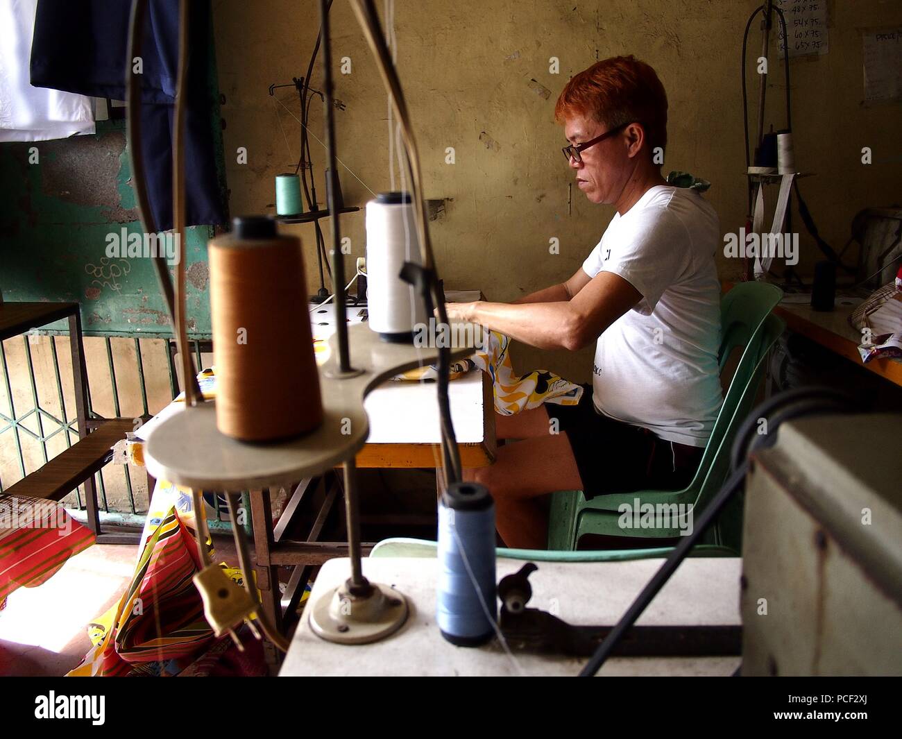 ANTIPOLO CITY, PHILIPPINES JULY 30, 2018 A tailor works on a dress