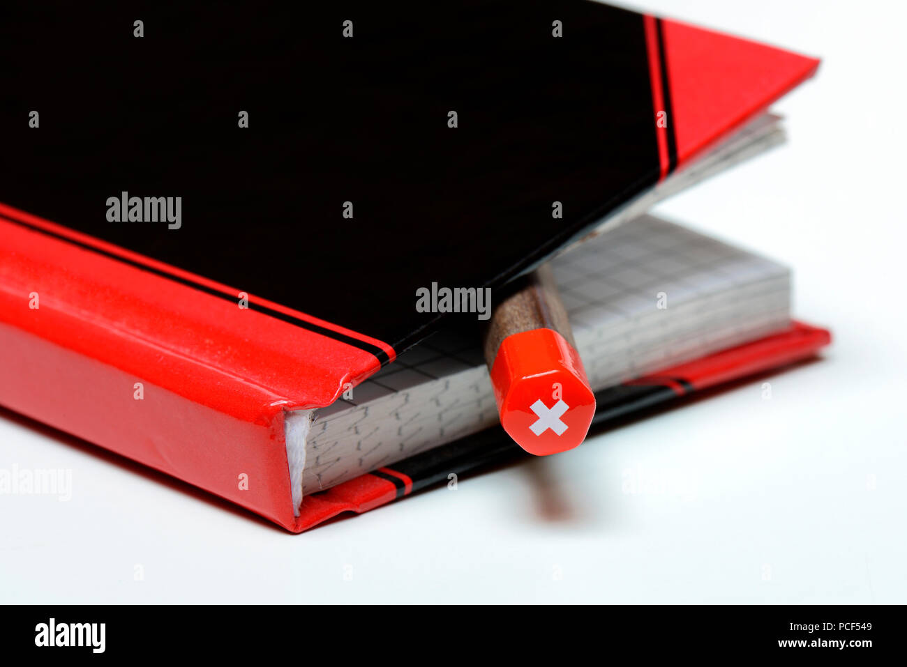 Bleistift in Notizbuch, Bleistift mit Schweizer Kreuz Stock Photo