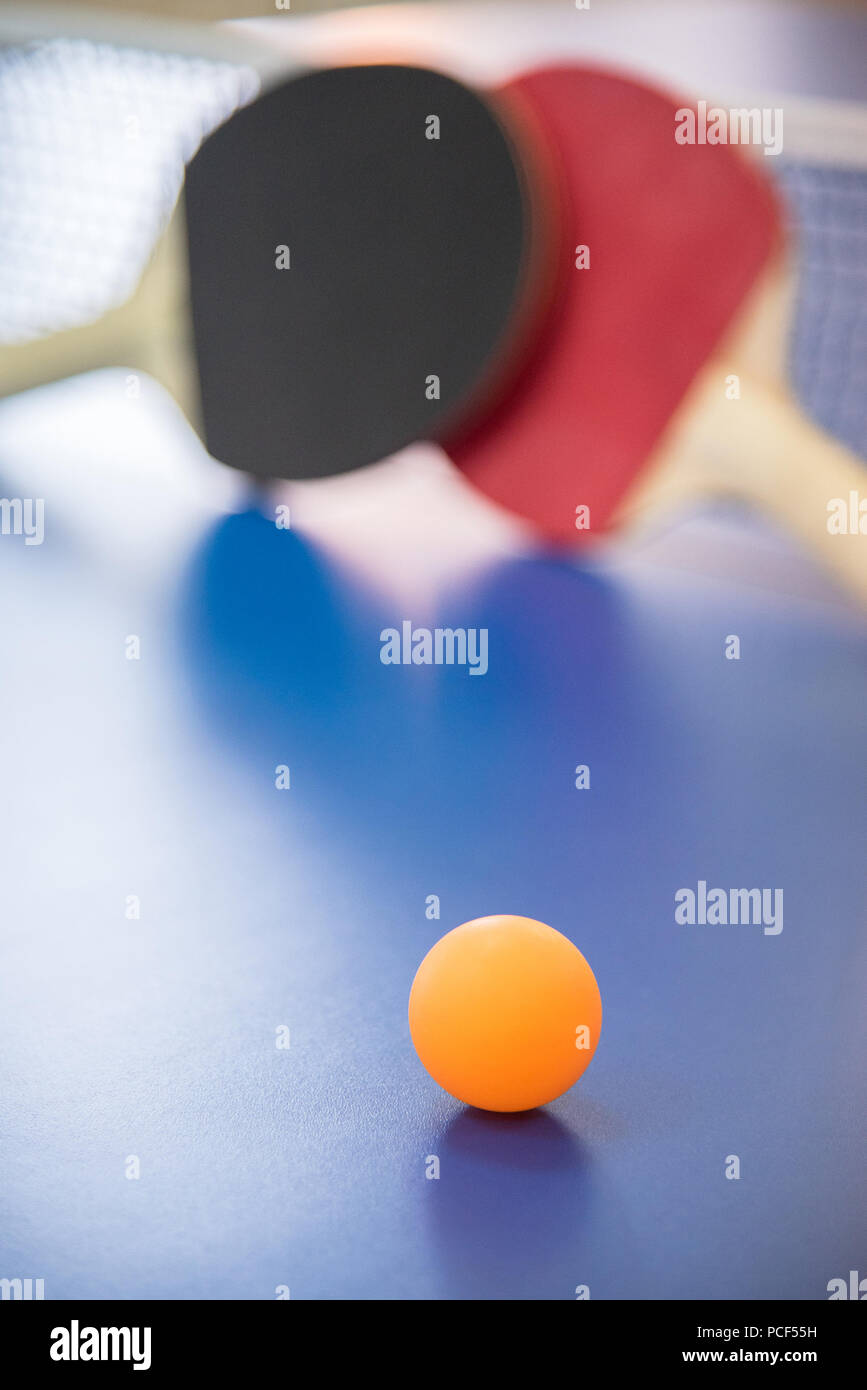 Table Tennis Colorful Racket Orange ball for table tennis and two wooden rackets of red and black ...