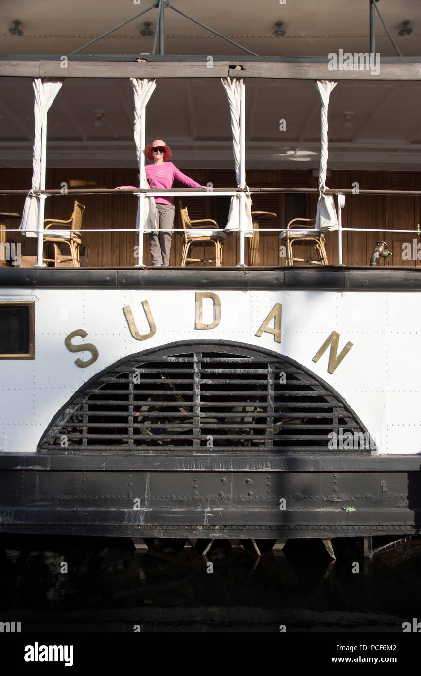 A woman tourist stands on the deck of the historic MS Sudan steamship moored on the Nile at Edfu, Egypt. Stock Photo