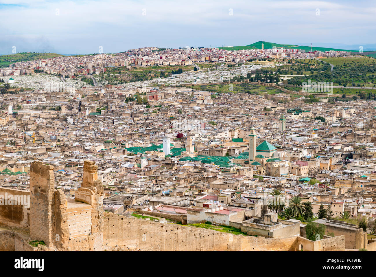 City view, Fez with city wall, University Al Quaraouiyine, behind it green hills, Fes, Morocco Stock Photo