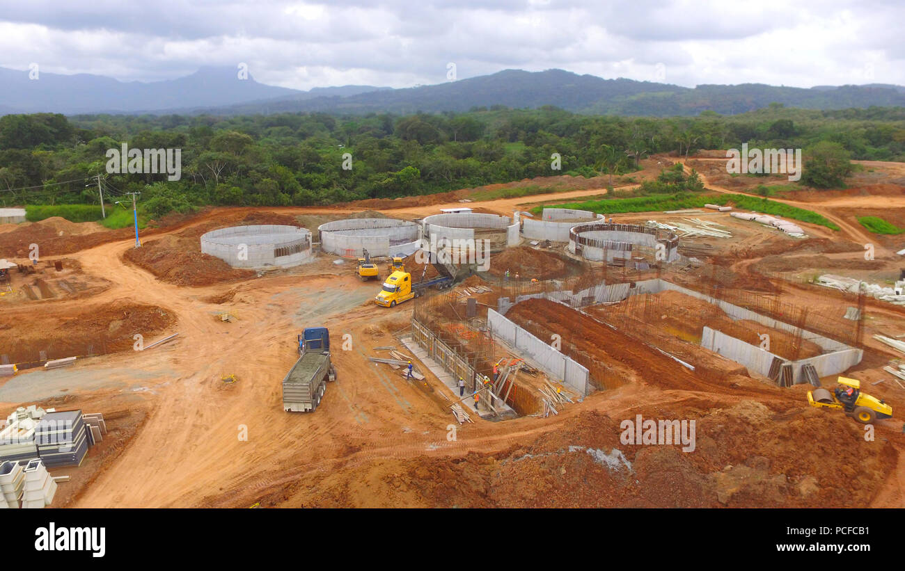 Aerial view of a construction site with trailers unloading raw ...