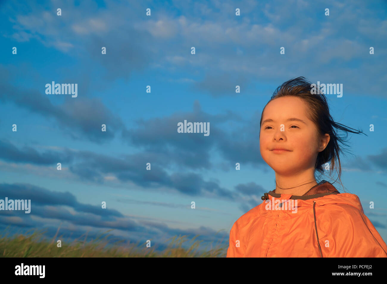 Portrait of little girl smiling on background of blue sky Stock Photo ...