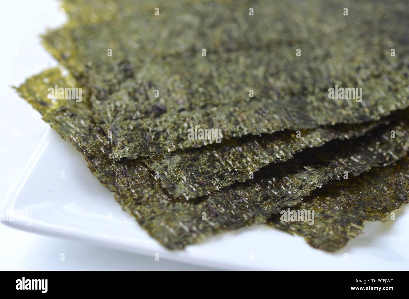 Detail top view of dried seaweed: nori. Isolated on white.Nutrient rich vegan, raw and healthy sea vegetables. Stock Photo