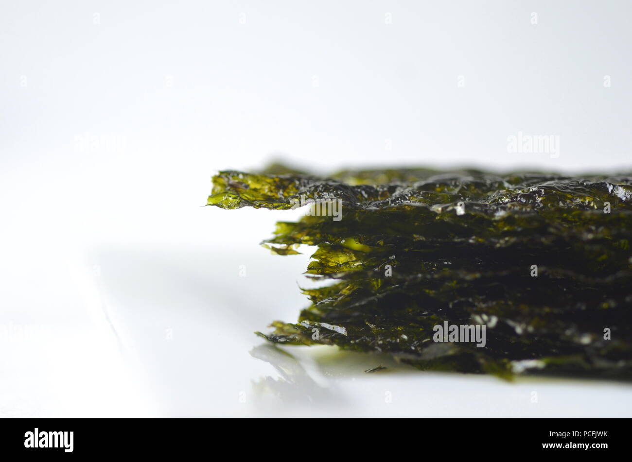 Detail top view of dried seaweed: nori. Isolated on white.Nutrient rich vegan, raw and healthy sea vegetables. Stock Photo