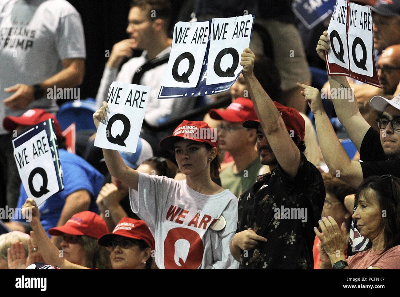 Tampa, Florida, USA. July 31, 2018 - Tampa, Florida, United States - Attendees at U.S. President Donald Trump's Make America Great Again Rally hold signs reading, 'We Are Q' on July 31, 2018 at the Florida State Fairgrounds in Tampa, Florida. The self-described followers of 'Q', an anonymous person or group of people who claim to be privy to government secrets, are believers in a fringe internet conspiracy theory called 'QAnon'. (Paul Hennessy/Alamy) Credit: Paul Hennessy/Alamy Live News Stock Photo