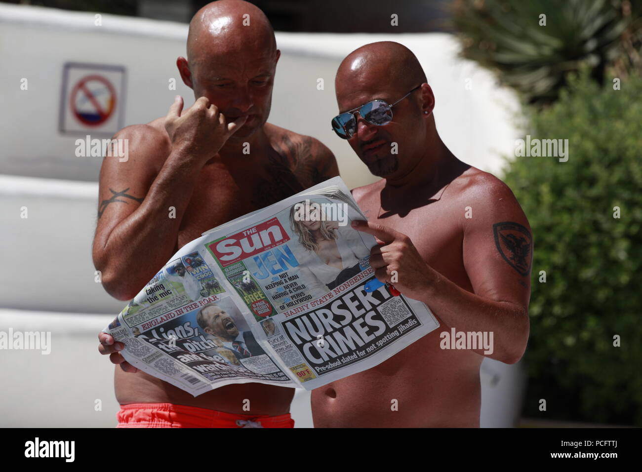 Roquetas de Mar, Almeria, Spain. 2nd Aug, 2018. Two suntanned men reading The Sun newspaper standing. Photo Credit: Paul Lawrenson /Alamy Live News Stock Photo