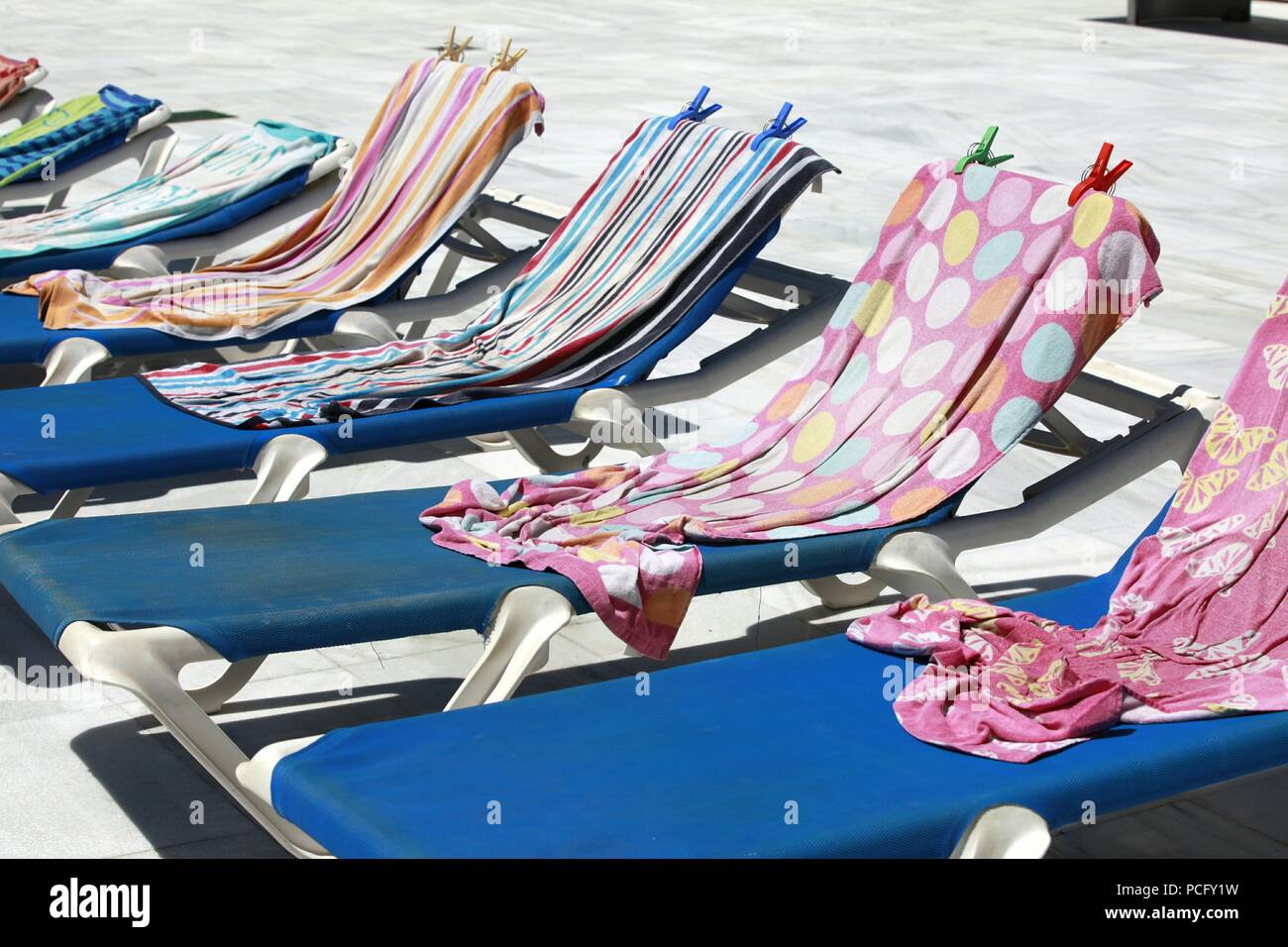Roquetas de Mar, Almeria, Spain. 2nd Aug, 2018. The heatwave that is hitting Spain is expected to exceed 43°C in some parts of the country. Row of empty sun loungers reserved with towels. Clothes pegs hold them in place. Photo Credit: Paul Lawrenson /Alamy Live News Stock Photo