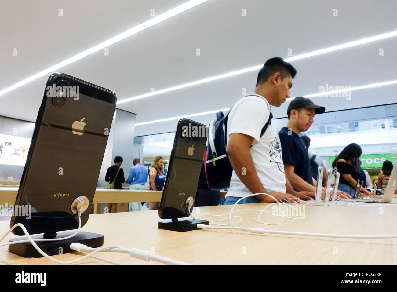 New York, USA. 2nd Aug, 2018. Customers select products at an Apple store in New York, the United States, Aug. 2, 2018. U.S. tech giant Apple became the first American company that saw its market cap hit 1 trillion U.S. dollars in the U.S. history after its shares rose 2.8 percent to a session high of 207.05 dollars around midday trading on Thursday. Credit: Wang Ying/Xinhua/Alamy Live News Stock Photo