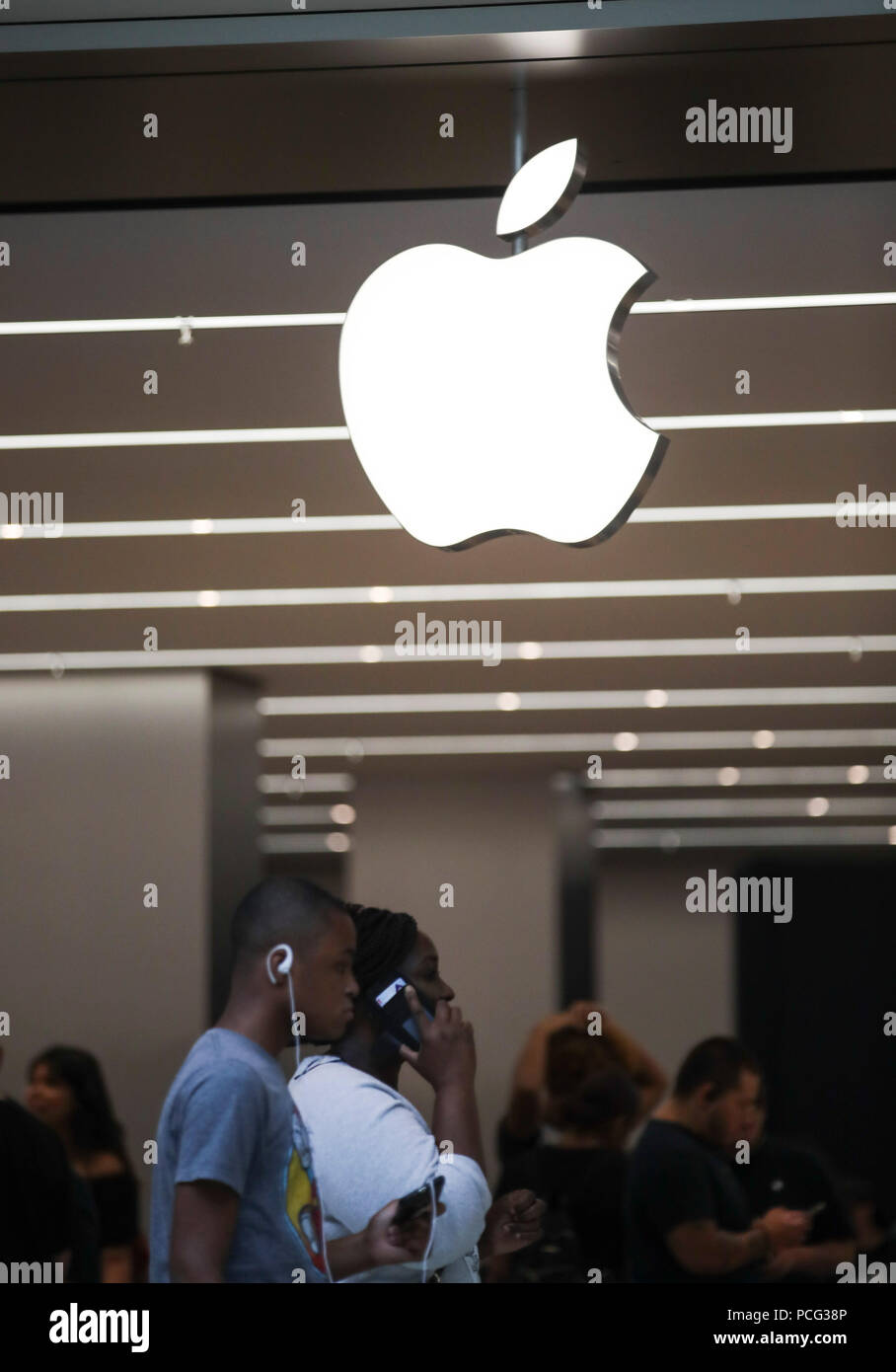 New York, USA. 2nd Aug, 2018. People walk past an Apple store in New York, the United States, Aug. 2, 2018. U.S. tech giant Apple became the first American company that saw its market cap hit 1 trillion U.S. dollars in the U.S. history after its shares rose 2.8 percent to a session high of 207.05 dollars around midday trading on Thursday. Credit: Wang Ying/Xinhua/Alamy Live News Stock Photo