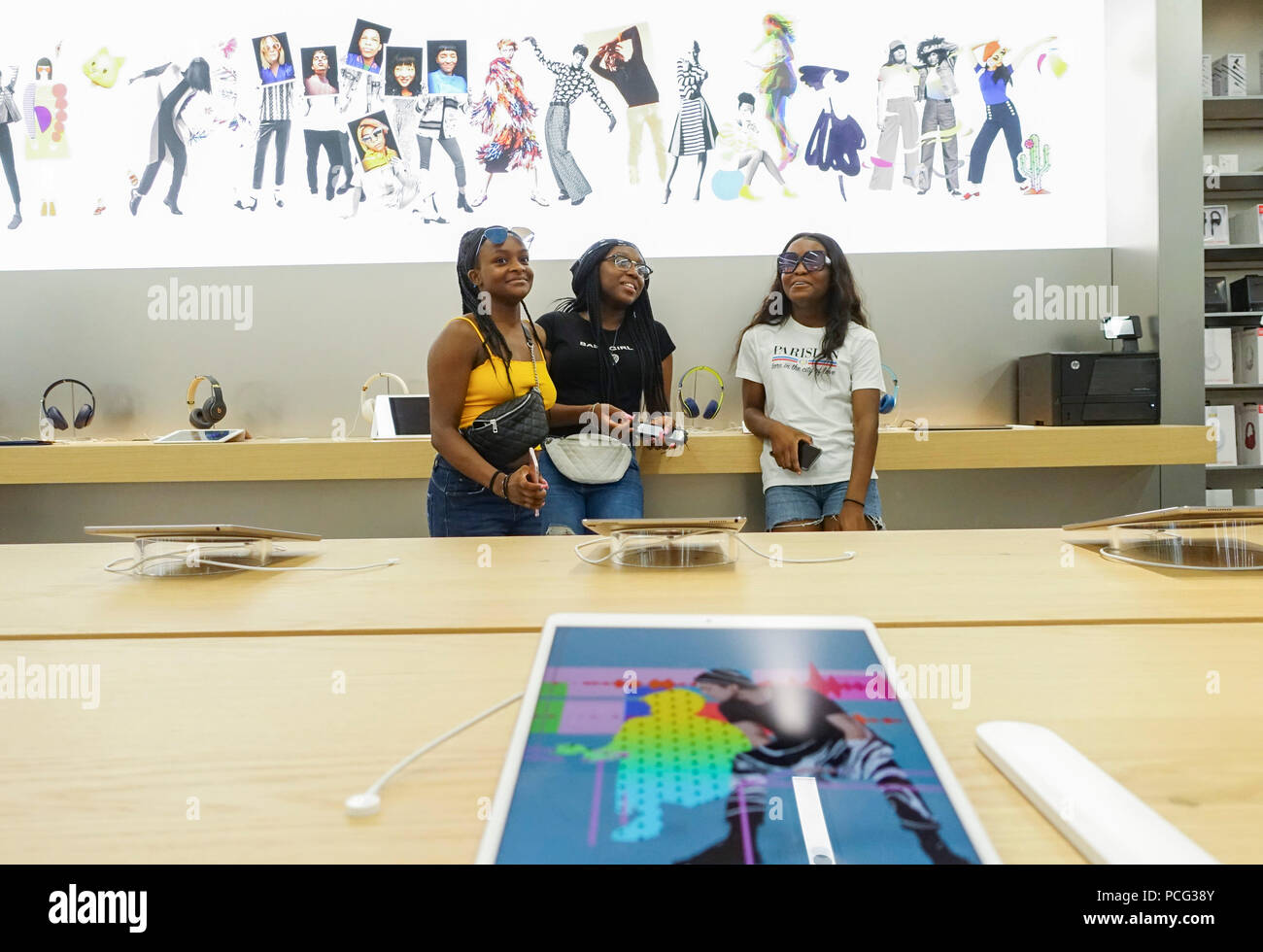 New York, USA. 2nd Aug, 2018. Customers are seen at an Apple store in New York, the United States, Aug. 2, 2018. U.S. tech giant Apple became the first American company that saw its market cap hit 1 trillion U.S. dollars in the U.S. history after its shares rose 2.8 percent to a session high of 207.05 dollars around midday trading on Thursday. Credit: Wang Ying/Xinhua/Alamy Live News Stock Photo