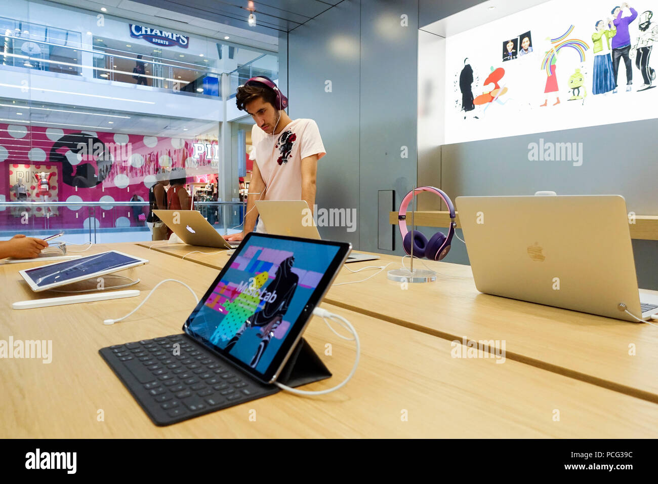 New York, USA. 2nd Aug, 2018. A customer tries a product at an Apple store in New York, the United States, Aug. 2, 2018. U.S. tech giant Apple became the first American company that saw its market cap hit 1 trillion U.S. dollars in the U.S. history after its shares rose 2.8 percent to a session high of 207.05 dollars around midday trading on Thursday. Credit: Wang Ying/Xinhua/Alamy Live News Stock Photo