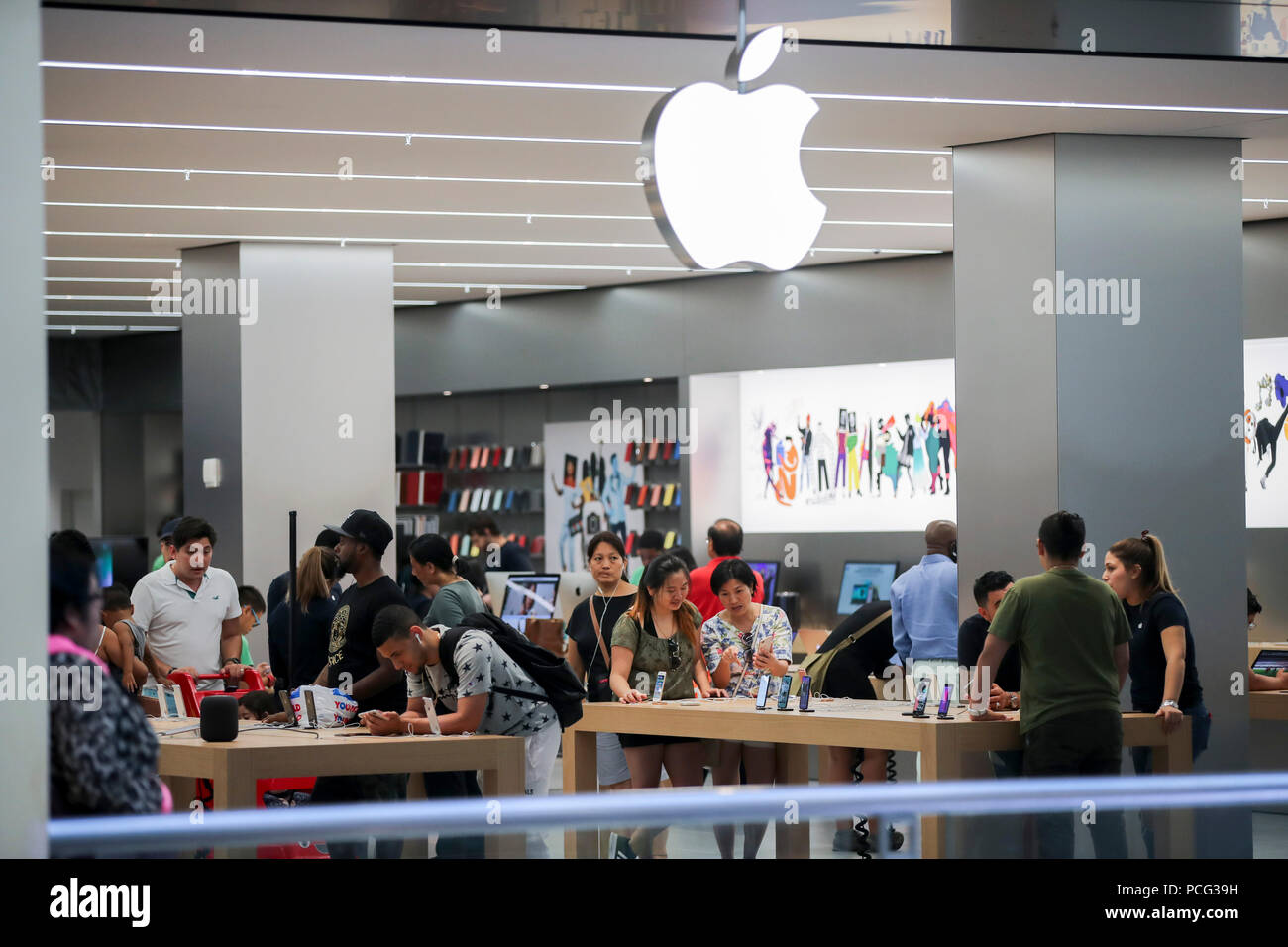 New York, USA. 2nd Aug, 2018. Customers select products at an Apple store in New York, the United States, Aug. 2, 2018. U.S. tech giant Apple became the first American company that saw its market cap hit 1 trillion U.S. dollars in the U.S. history after its shares rose 2.8 percent to a session high of 207.05 dollars around midday trading on Thursday. Credit: Wang Ying/Xinhua/Alamy Live News Stock Photo