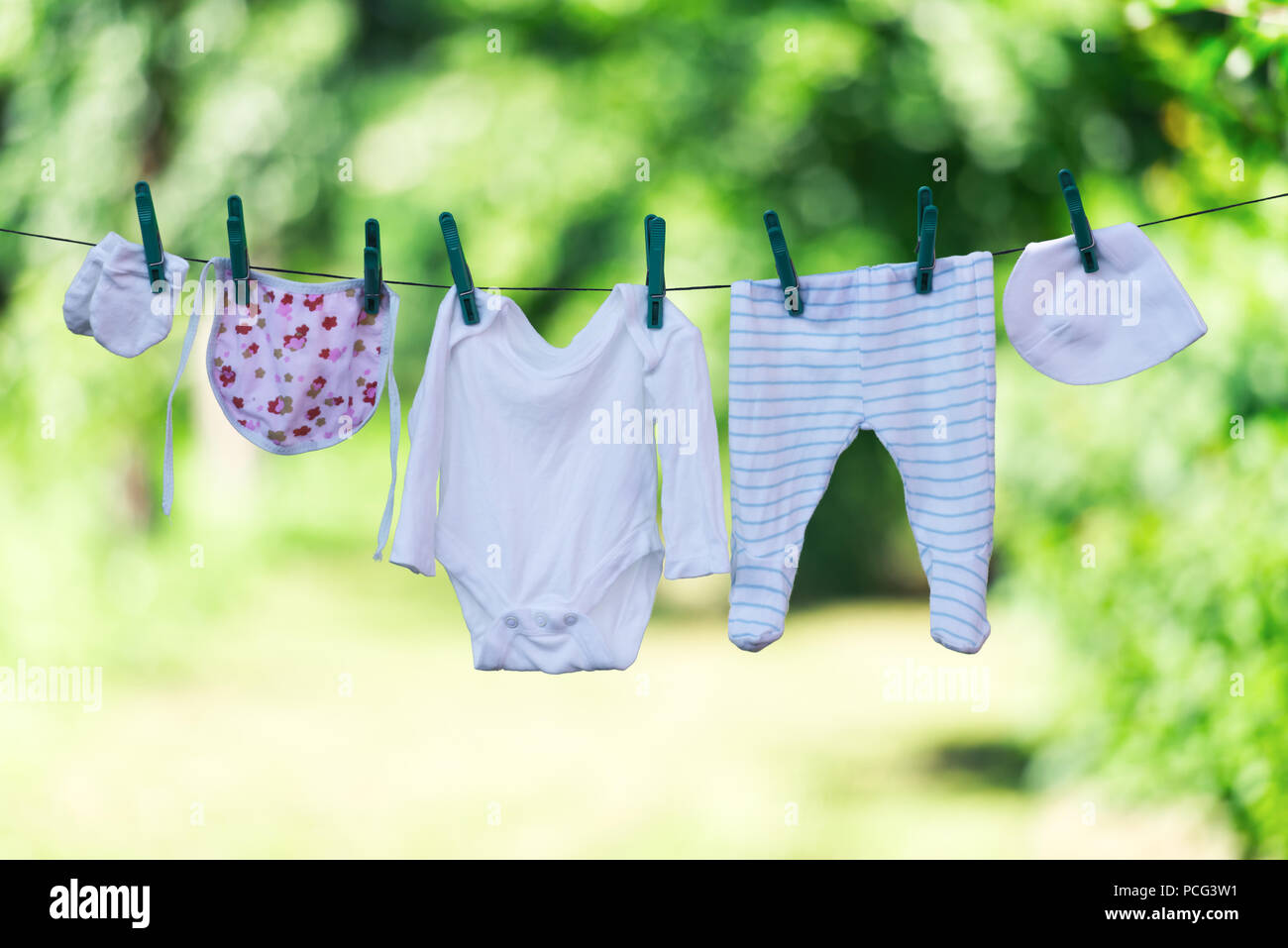 Baby clothes on clothesline in garden Stock Photo