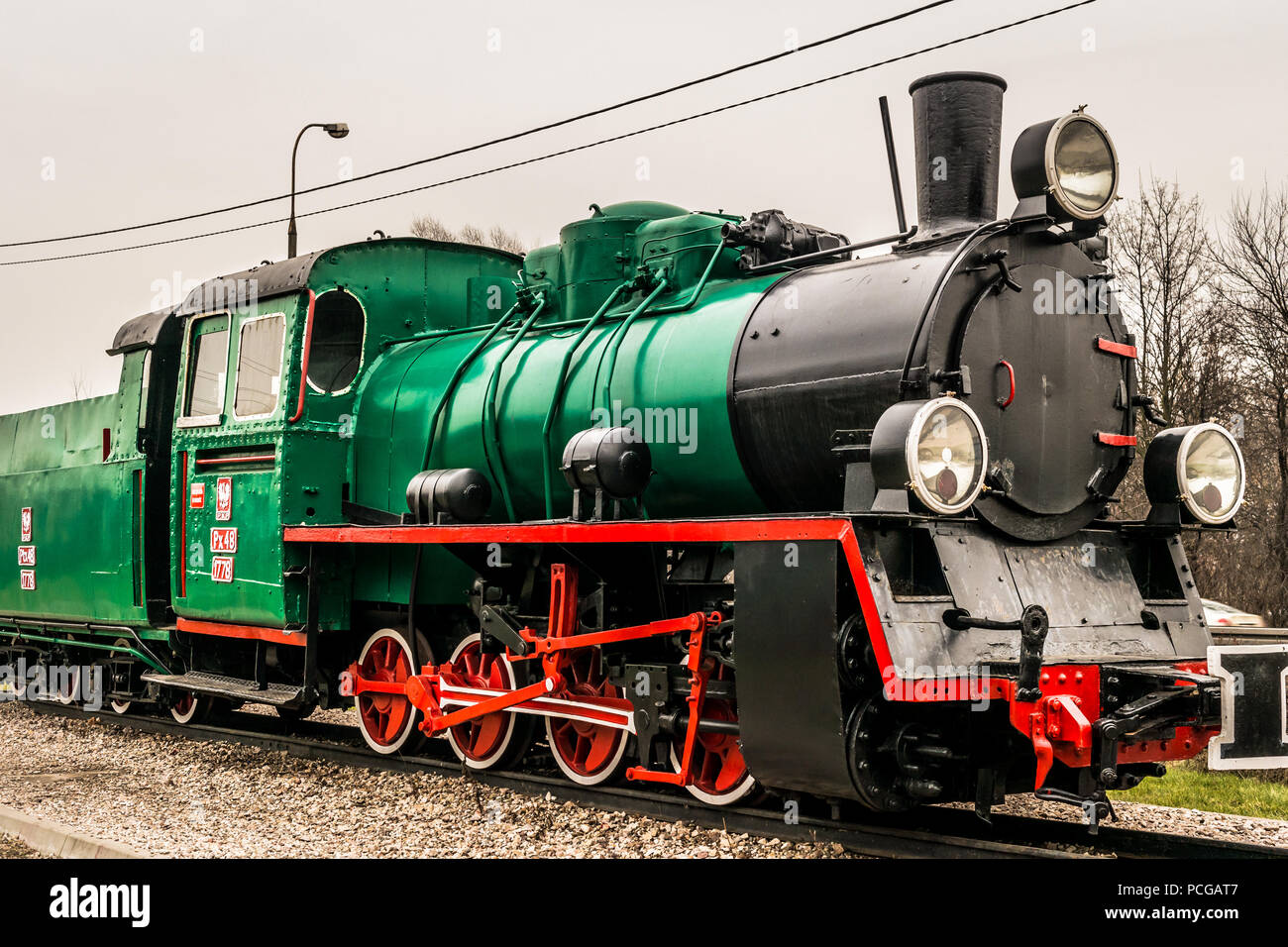 A green steam locomotive engine on display in Marki, Poland