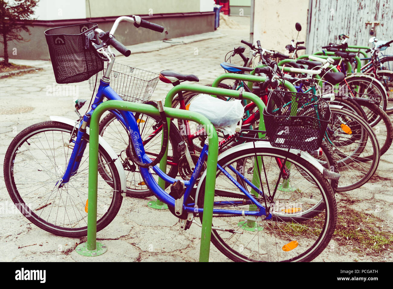 A row of commuters' bikes lined up and secured to racks with padlocks and cables in an urban environment.  Pollution free transport for healthy living Stock Photo
