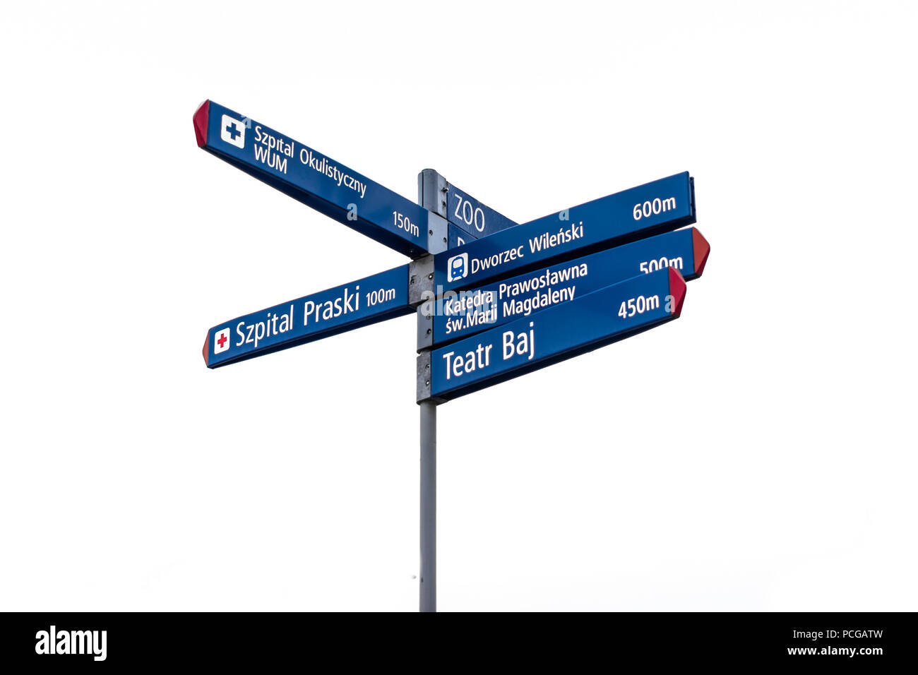 Blue signpost in Warsaw, Poland pointing the direction to the zoo, hospital, theatre, cathedral, underground station. Stock Photo