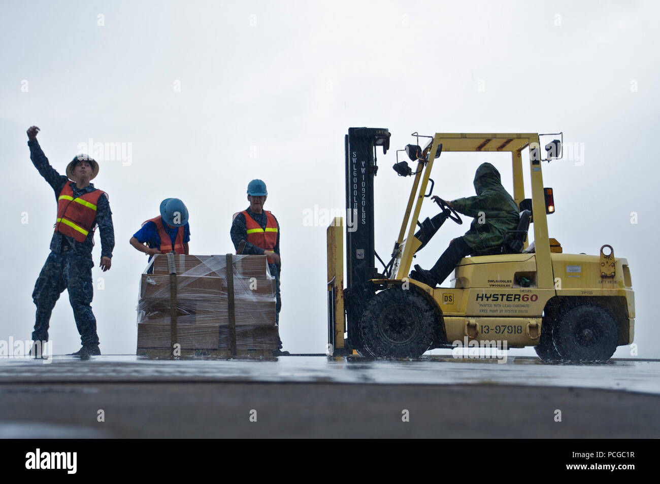 Sailors assigned to the amphibious assault ship USS Bonhomme Richard (LHD 6) load supplies during a port call in Okinawa, Japan. The ship is en route to relieve USS Essex (LHD 2) in Sasebo, Japan. Stock Photo