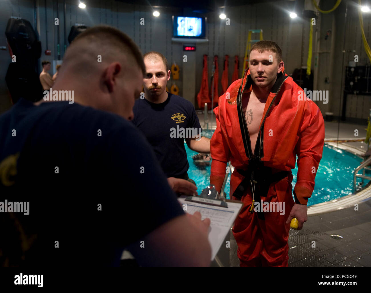 Seaman Apprentice Kenton Mifer, electronics technician, is checked by hospital corpsmen after emerging from the escape trainer at the Basic Enlisted Submarine School at Naval Submarine Base New London, Conn. Submarine escape training is designed to build skill and confidence in escape procedures using the submarine's escape immersion equipment suit. Stock Photo