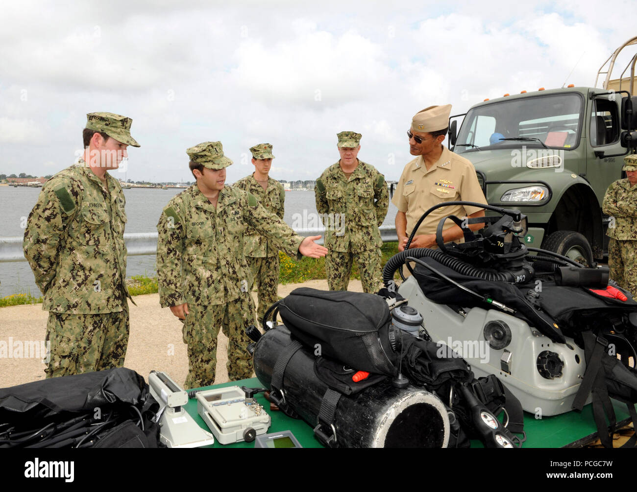 VIRGINIA BEACH, Va. – Sailors from Explosive Ordnance Disposal Group (EODGRU) Two explain underwater diving equipment to Adm. Cecil Haney, commander of U.S. Pacific Fleet (CPF), during a visit to learn about Navy Expeditionary Combat Command’s (NECC) capabilities at Joint Expeditionary Base Little Creek-Fort Story Aug. 23. Navy EOD technicians conduct demolition of hazardous munitions, pyrotechnics and retrograde explosives in support of military and civilian law enforcement agencies. Stock Photo