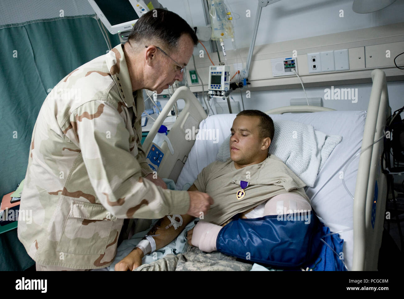 Chairman of the Joint Chiefs of Staff Navy Adm. Mike Mullen presents a Purple Heart medal to Army Sgt. Marcus Love at Bagram Air Field, Afghanistan, July 14, 2009. Love, from Delta Company, 1st Battalion, 87th Infantry Regiment, 3rd Brigade Combat Team, 10th Mountain Division out of Fort Drum, N.Y., was presented the medal for a gunshot wound received earlier in the day. ( Stock Photo