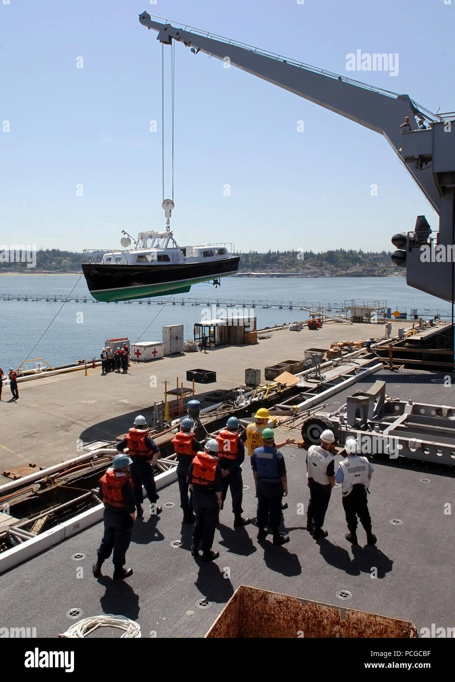 Members of deck department work to bring the Commander, Carrier Strike Group 9, admiral's barge aboard Nimitz-class aircraft carrier USS Abraham Lincoln (CVN 72). Lincoln is conducting training, crew certification, and preparation for the ship's return to operational status following a shipyard availability period. Stock Photo